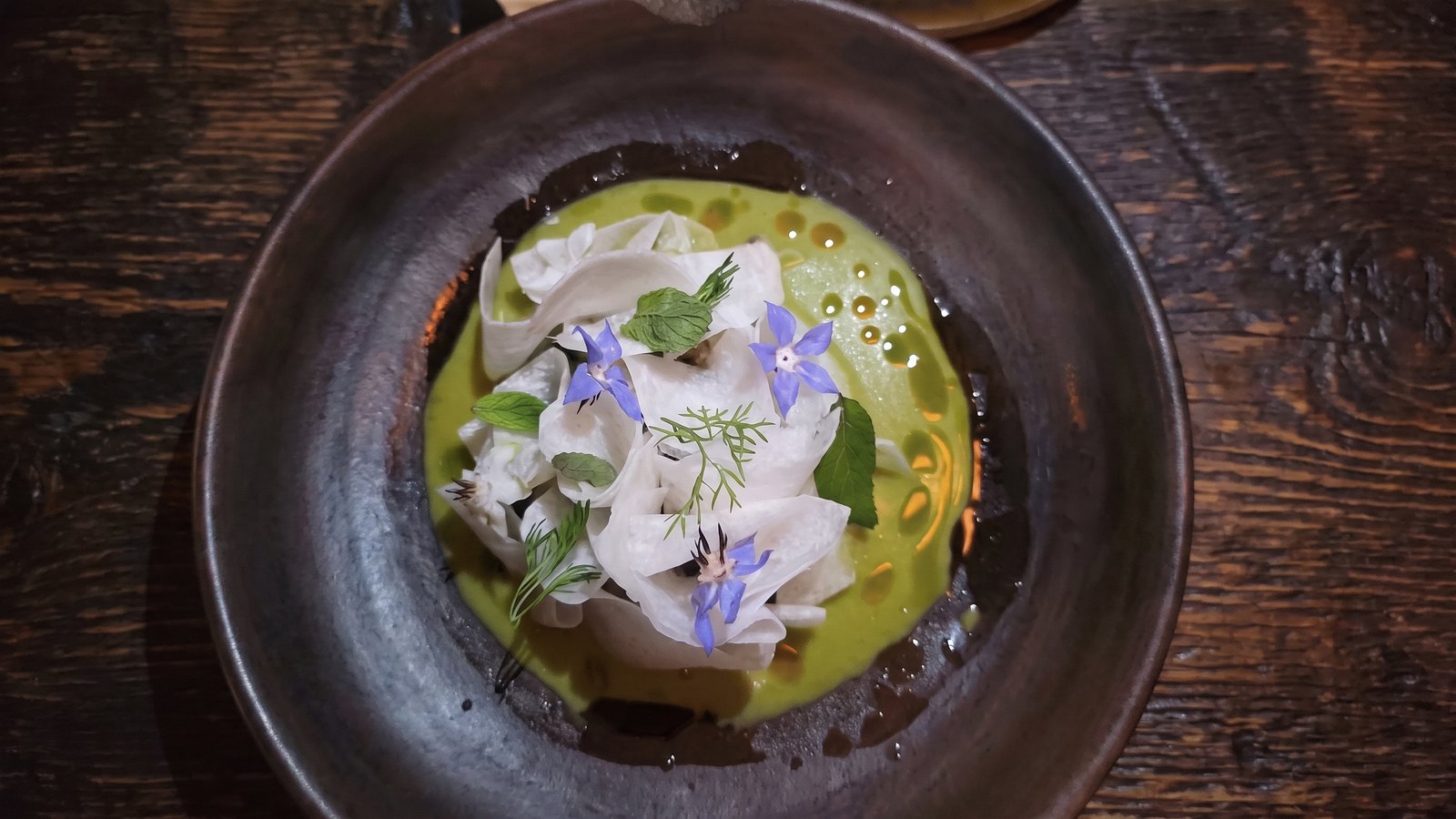 Green sauce with white ribbons and blue flowers